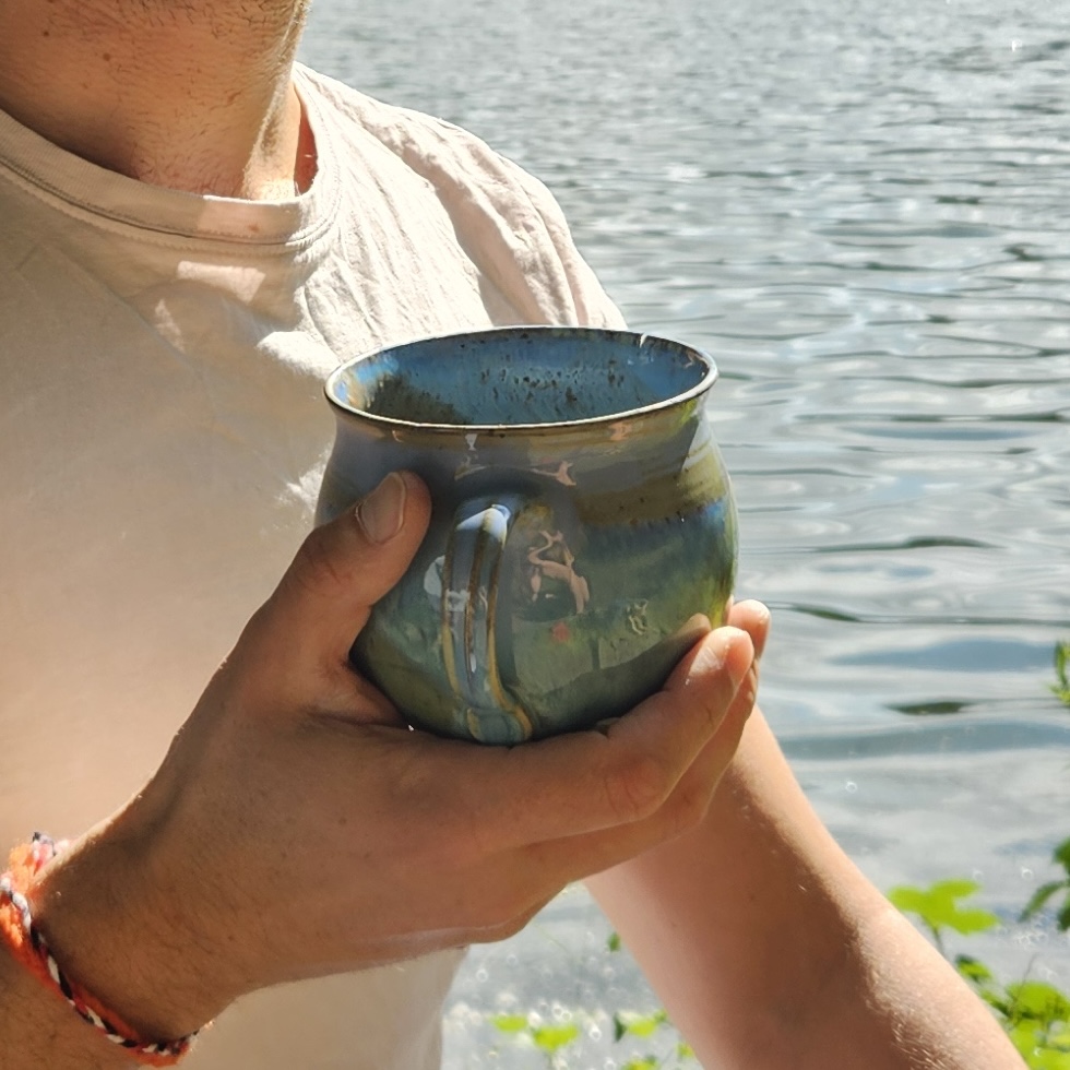 Cacao cup in the hand of shamanuel at a magic lake
